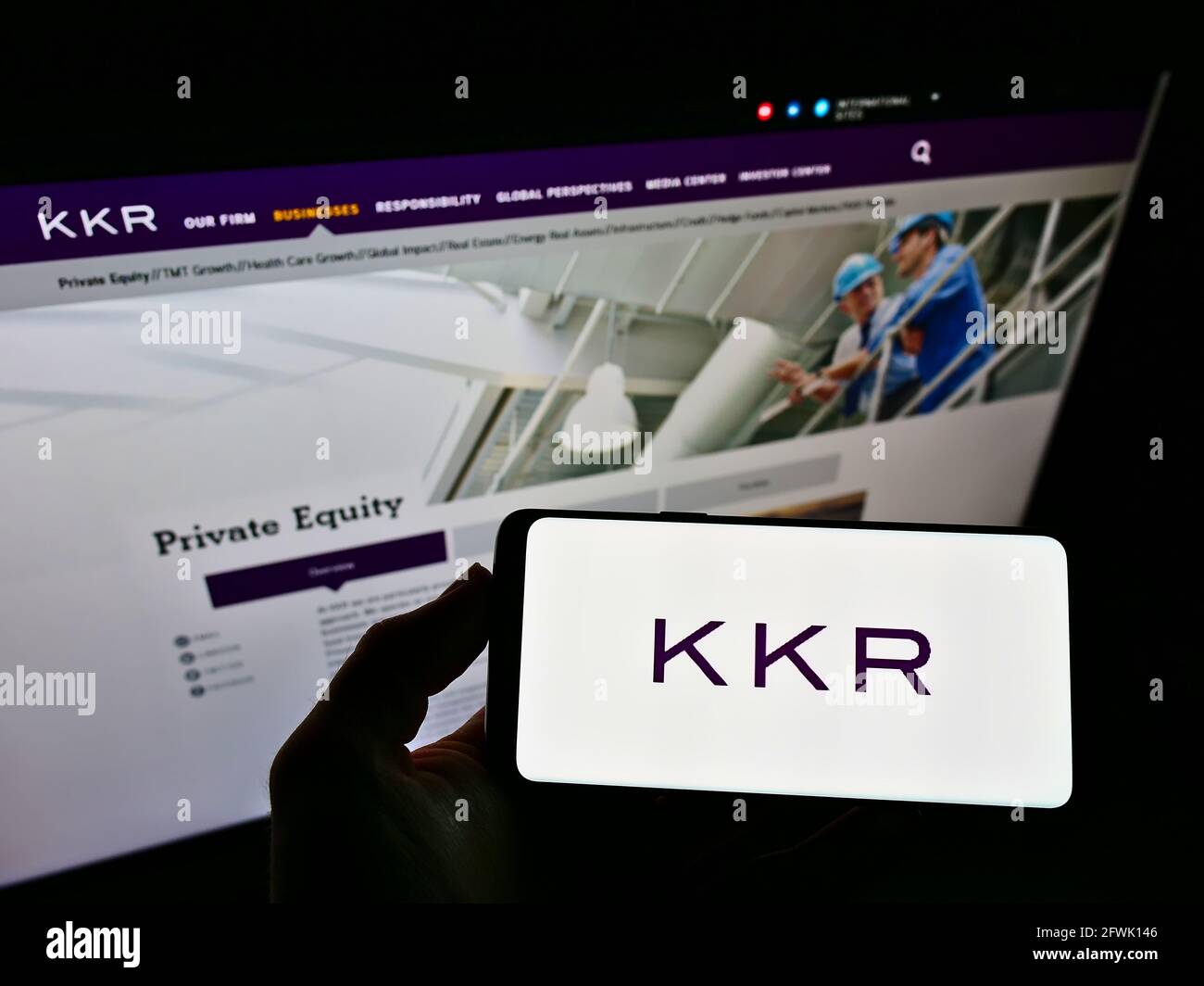 Personne tenant un téléphone mobile avec le logo d'entreprise de la société d'investissement américaine KKR and Co. Inc. Sur l'écran devant le site Web de l'entreprise. Mise au point sur l'affichage du téléphone. Banque D'Images