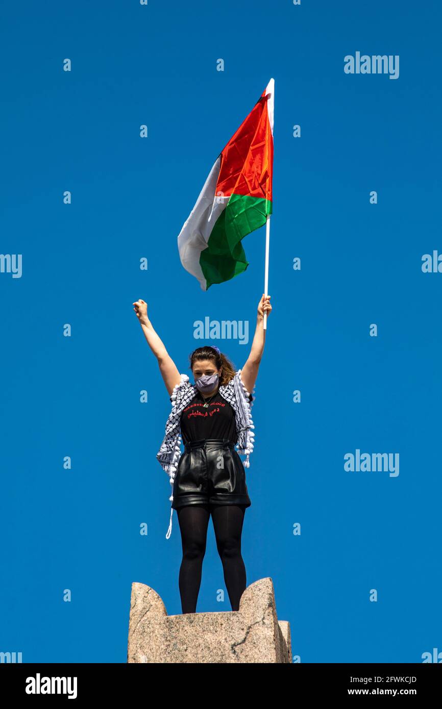 Jeune femme avec un masque de visage agitant le drapeau de la Palestine lors de la marche de solidarité au nom de la Palestine à Helsinki, en Finlande Banque D'Images
