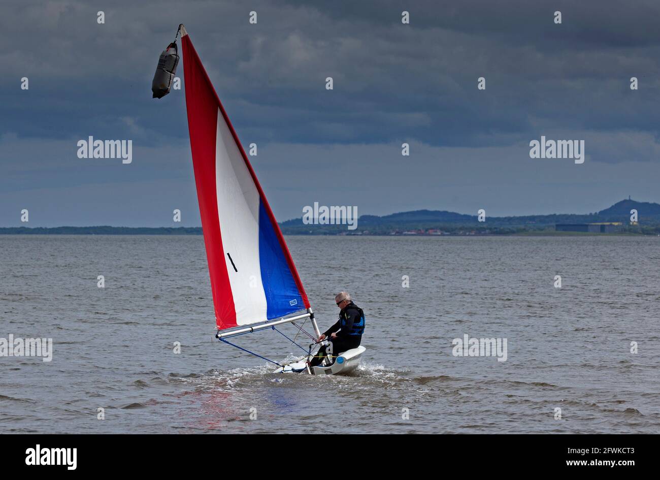 Portobello, Édimbourg, Écosse, météo britannique. 23 mai 2021. Nuageux et à 12 degrés avec une brise sur le rivage, mais assez pour donner à ce seul vent mâle dans ses voiles pour manœuvrer son canot sur le Firth of Forth. Crédit : Arch White/Alamy Live News. Banque D'Images