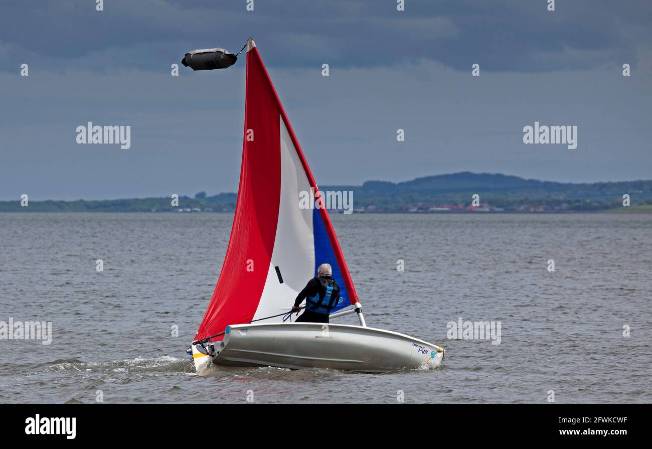 Portobello, Édimbourg, Écosse, météo britannique. 23 mai 2021. Nuageux et à 12 degrés avec une brise sur le rivage, mais assez pour donner à ce seul vent mâle dans ses voiles pour manœuvrer son canot sur le Firth of Forth. Crédit : Arch White/Alamy Live News. Banque D'Images