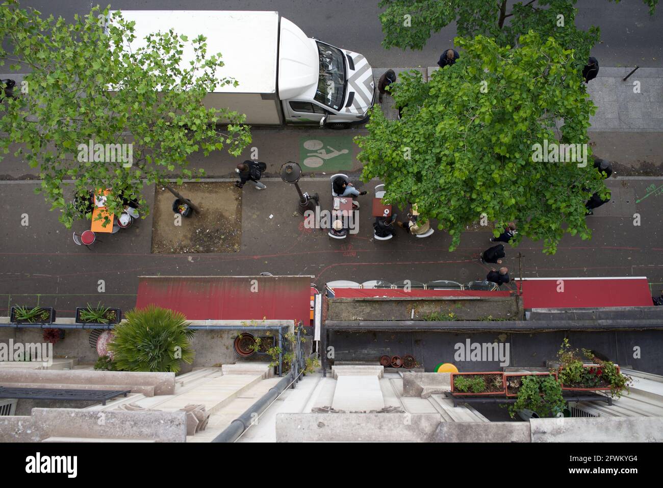 Vue depuis un balcon de boulevard des Parisiens assis sur une terrasse temporaire de café, l'un des nombreux sur les trottoirs de Paris permettant aux clients de boire dehors après que les restrictions de verrouillage de Covid-19 ont été assouplies - Boulevard Barbès, Paris, France - Mai 2021 Banque D'Images