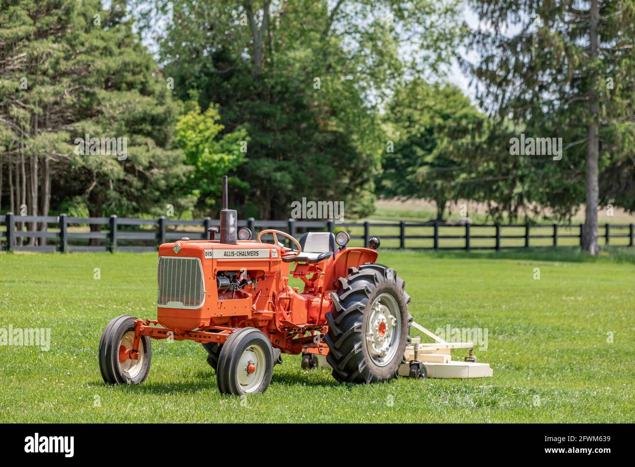 Un tracteur de ferme Allis Chalmers ornage dans un champ vert Banque D'Images