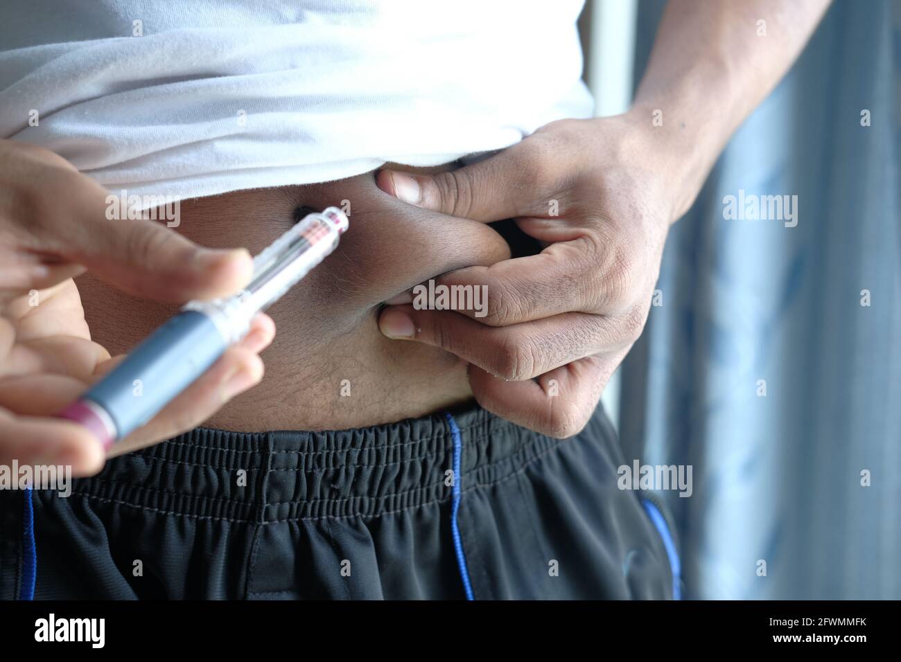 jeune homme main utilisant l'insuline stylo gros plan Banque D'Images