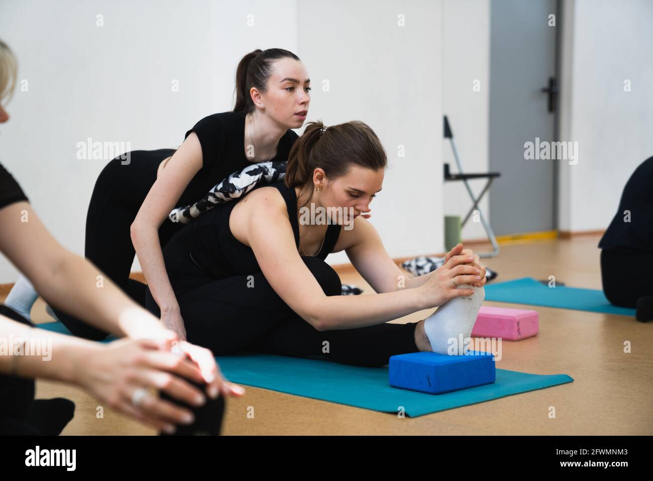 Femme avec entraîneur faisant des exercices d'étirement Banque D'Images