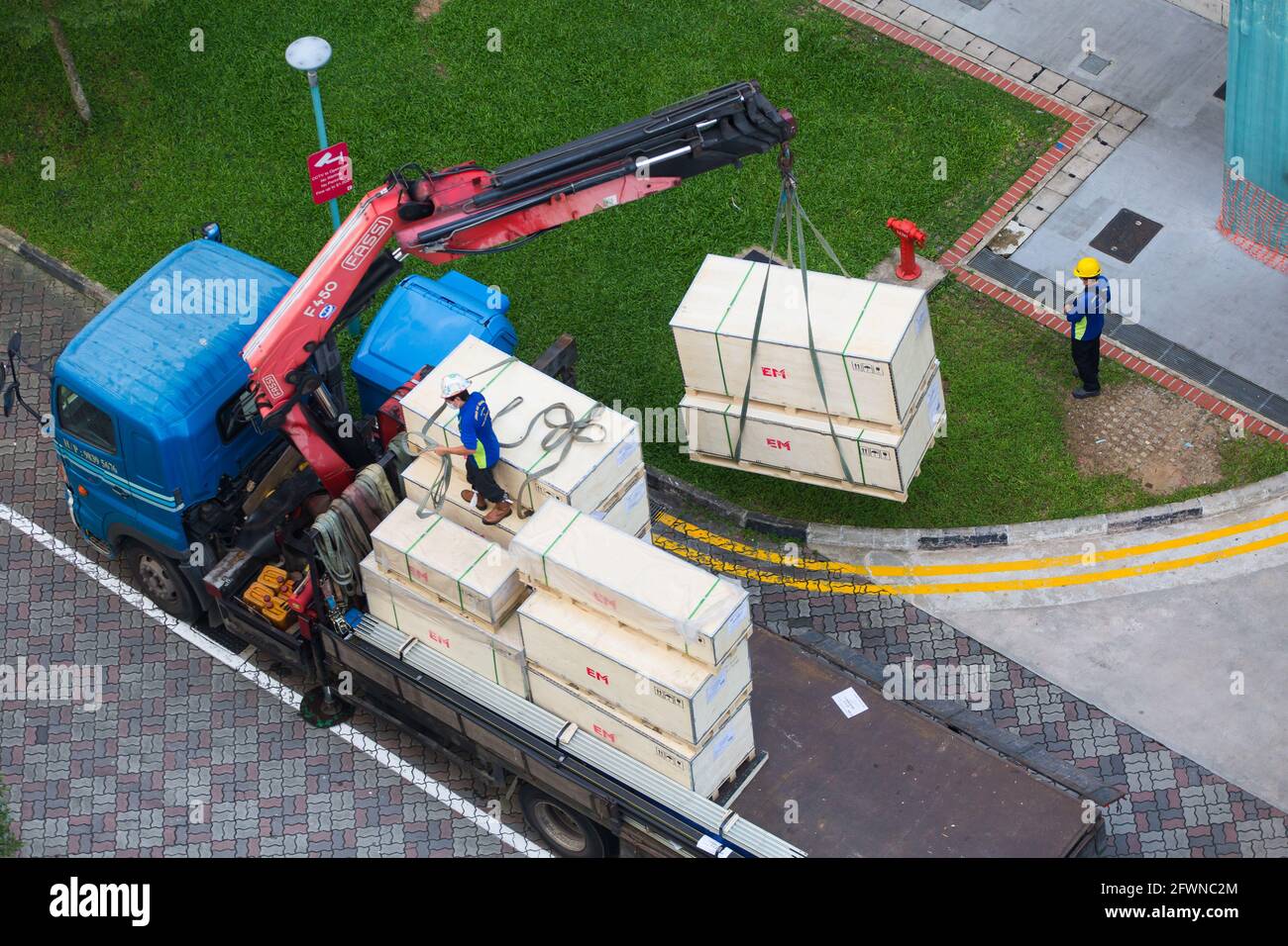 Vue aérienne d'une grue hydraulique déchargeant des caisses massives pendant une opération. Singapour. Banque D'Images