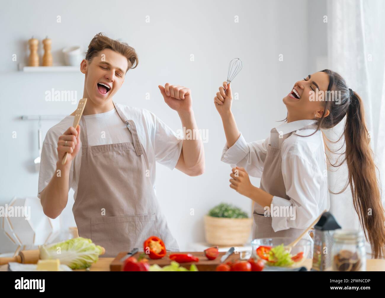 Une alimentation saine à la maison. Le couple heureux aimant prépare le bon repas dans la cuisine. Banque D'Images