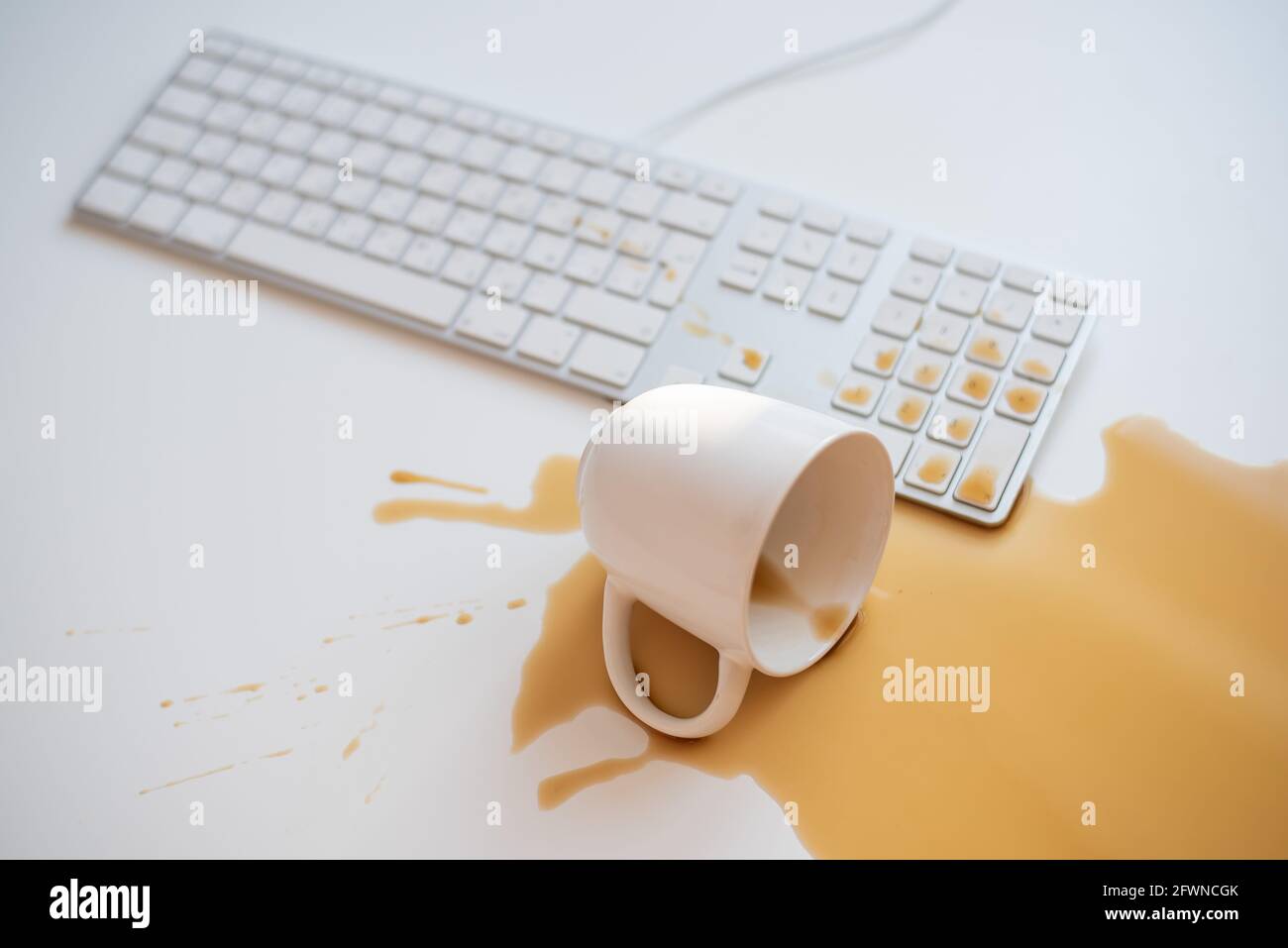 Café noir renversé sur un clavier d'ordinateur à un blanc tableau Banque D'Images Café noir renversé sur un clavier d'ordinateur à un blanc tableau Banque D'Images