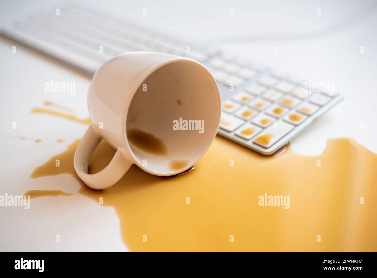 Café noir renversé sur un clavier d'ordinateur à un blanc tableau Banque D'Images Café noir renversé sur un clavier d'ordinateur à un blanc tableau Banque D'Images