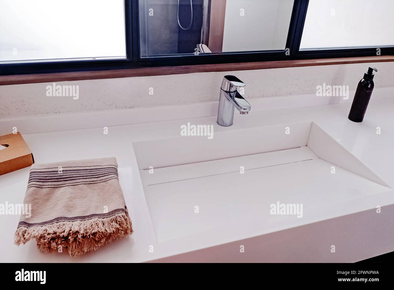 Lavabo dans l'intérieur moderne de la salle de bains, serviette et savon liquide. Banque D'Images