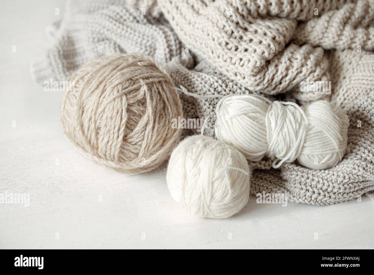 Gros plan de boules de fils de couleurs pastel et tricotés pull confortable Banque D'Images