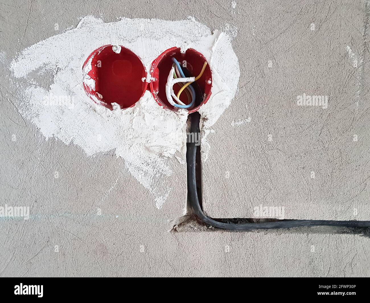 Les fils électriques avec les câbles à la maison. Nouvelles prises électriques. Prise murale en béton Banque D'Images