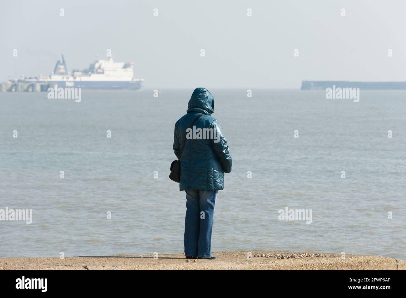 Femme regardant le port de ferry, front de mer, Douvres, Royaume-Uni. 8 mars 2011 Banque D'Images