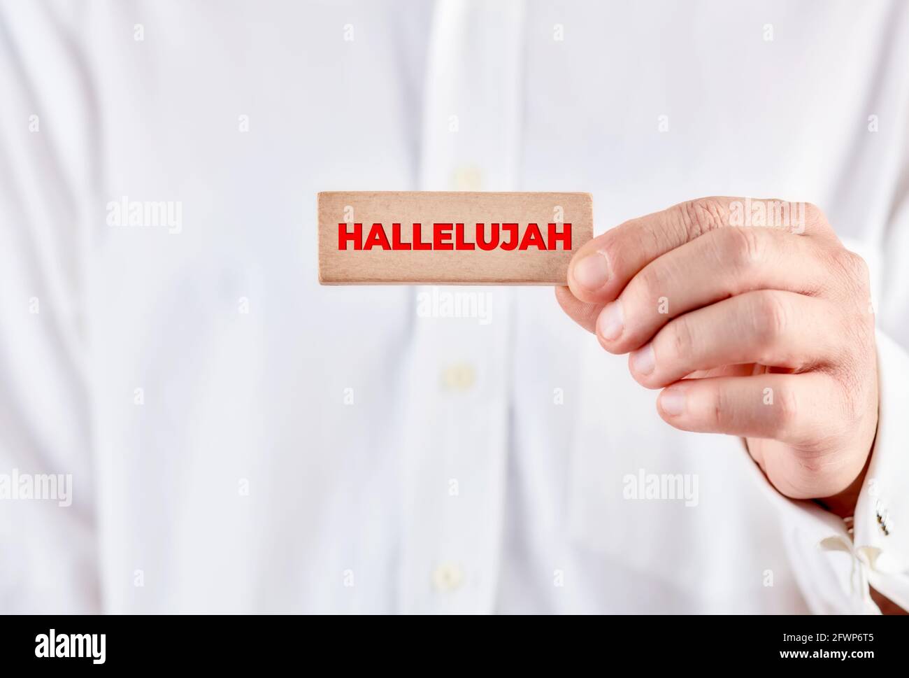 Main mâle tient un bloc de bois avec le mot hallelujah. Louant le Dieu, concept de religion. Banque D'Images