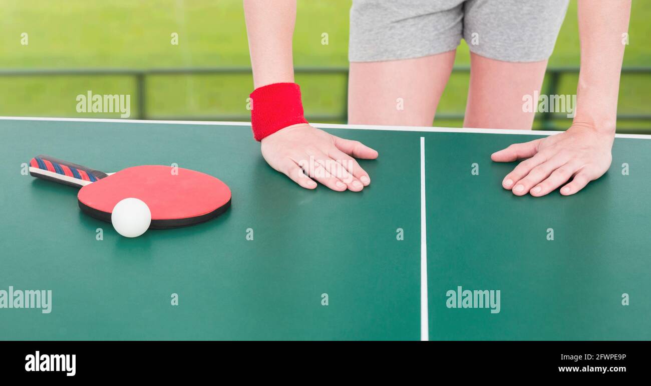 Composition de la section médiane de la joueuse de tennis de table penchée sur table avec boule et raquette Banque D'Images