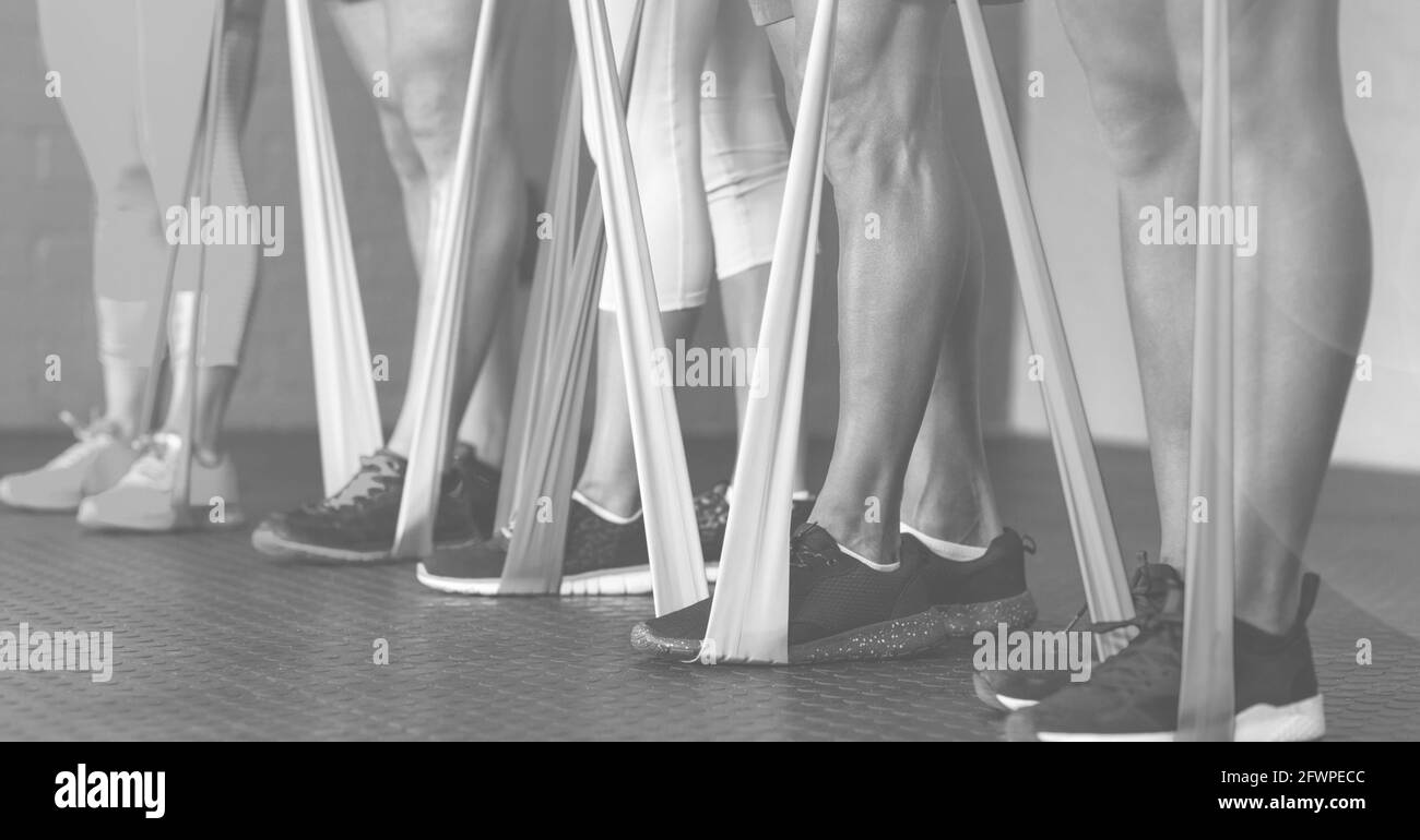 Composition de la section basse des femmes s'exerçant avec des bandes de caoutchouc en cours de fitness en noir et blanc Banque D'Images