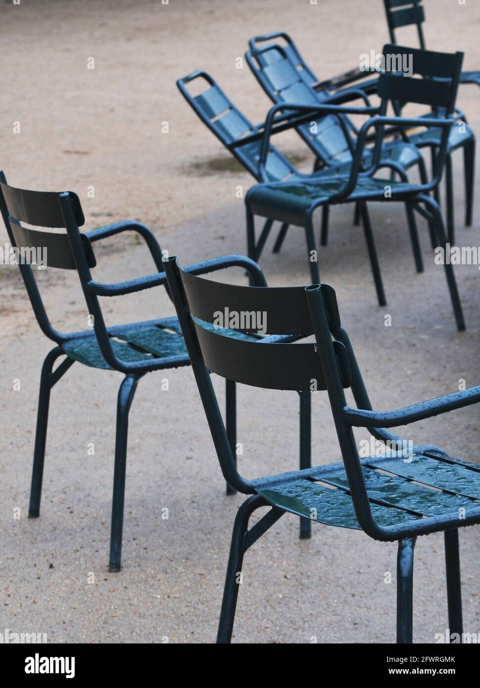 Chaises bleues dans le parc par temps de pluie Banque D'Images
