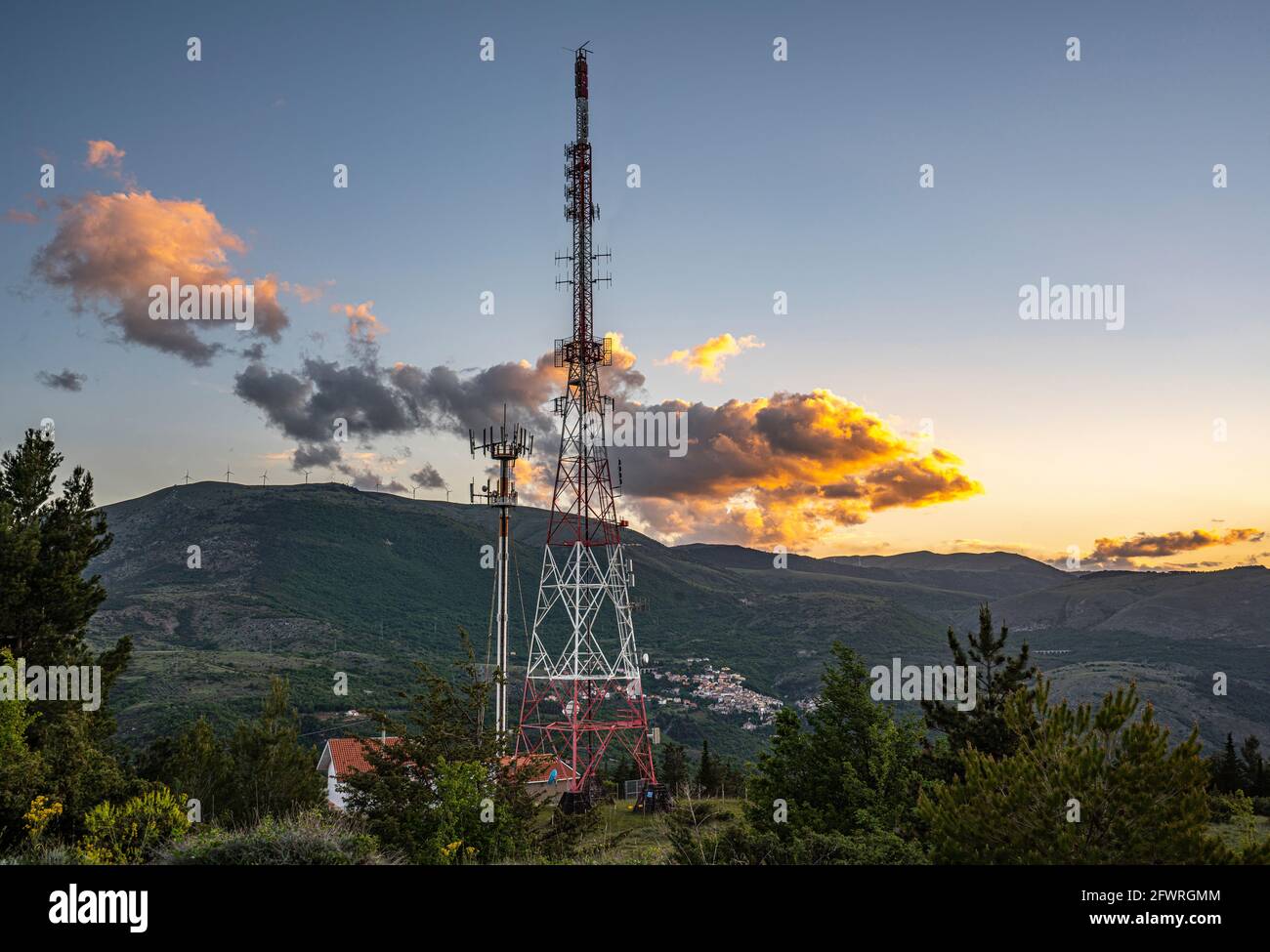 Paysage de montagne avec une grande antenne de communication avec des nuages illuminés par un coucher de soleil orange. Abruzzes, Italie, Europe Banque D'Images