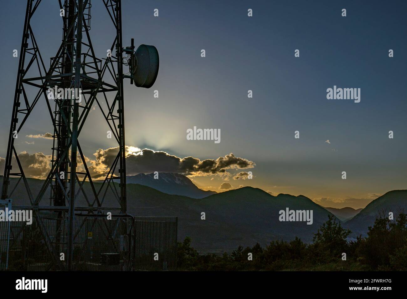 Silhouette des antennes et des répéteurs de signaux de téléphone et de télévision au coucher du soleil. Abruzzes, Italie, Europe Banque D'Images