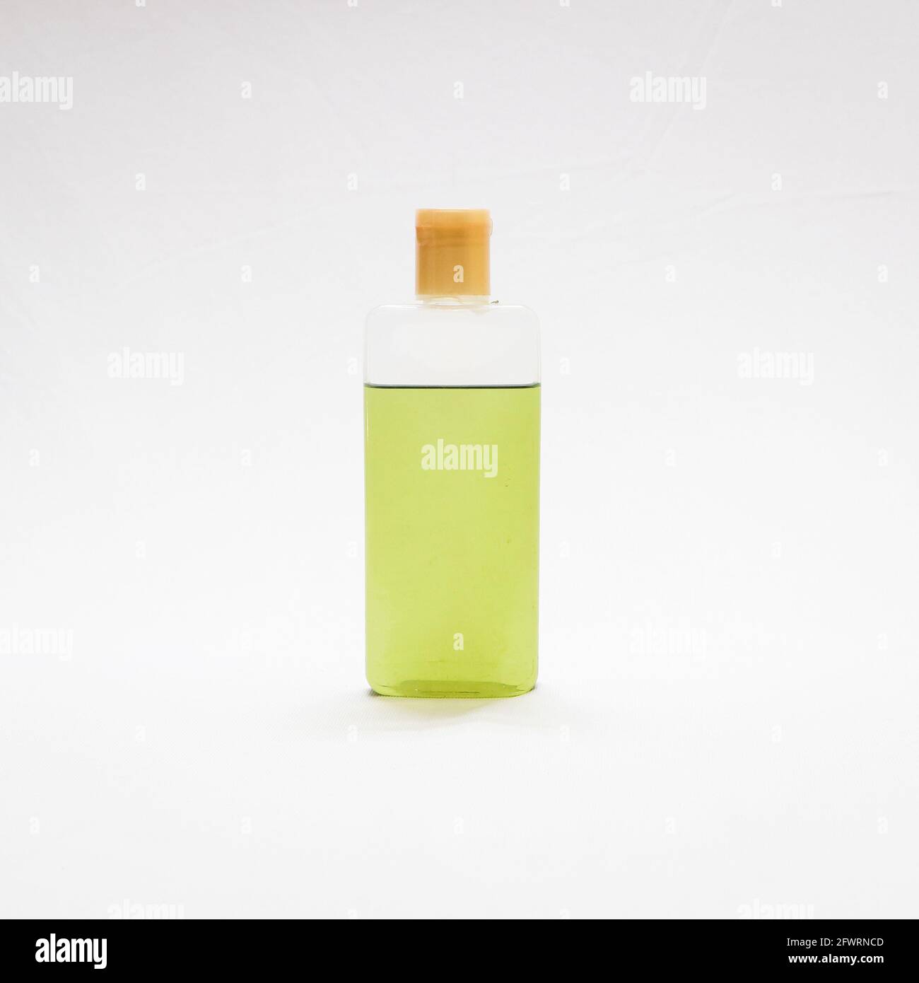 huile de cheveux vert naturel ayurvédique dans une bouteille en plastique transparent isolée dans un fond blanc Banque D'Images