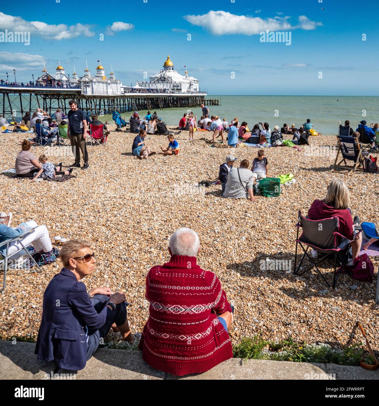 Eastbourne Beach and Pier, East Sussex, Angleterre. Une scène de plage à la hauteur de l'été anglais rempli de touristes appréciant le temps chaud. Banque D'Images