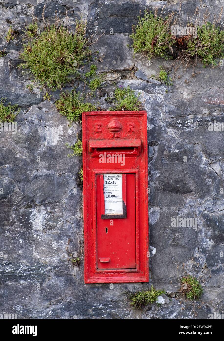 Boîte postale rouge fixée au mur, Tarbert, Argyll, Écosse. Banque D'Images