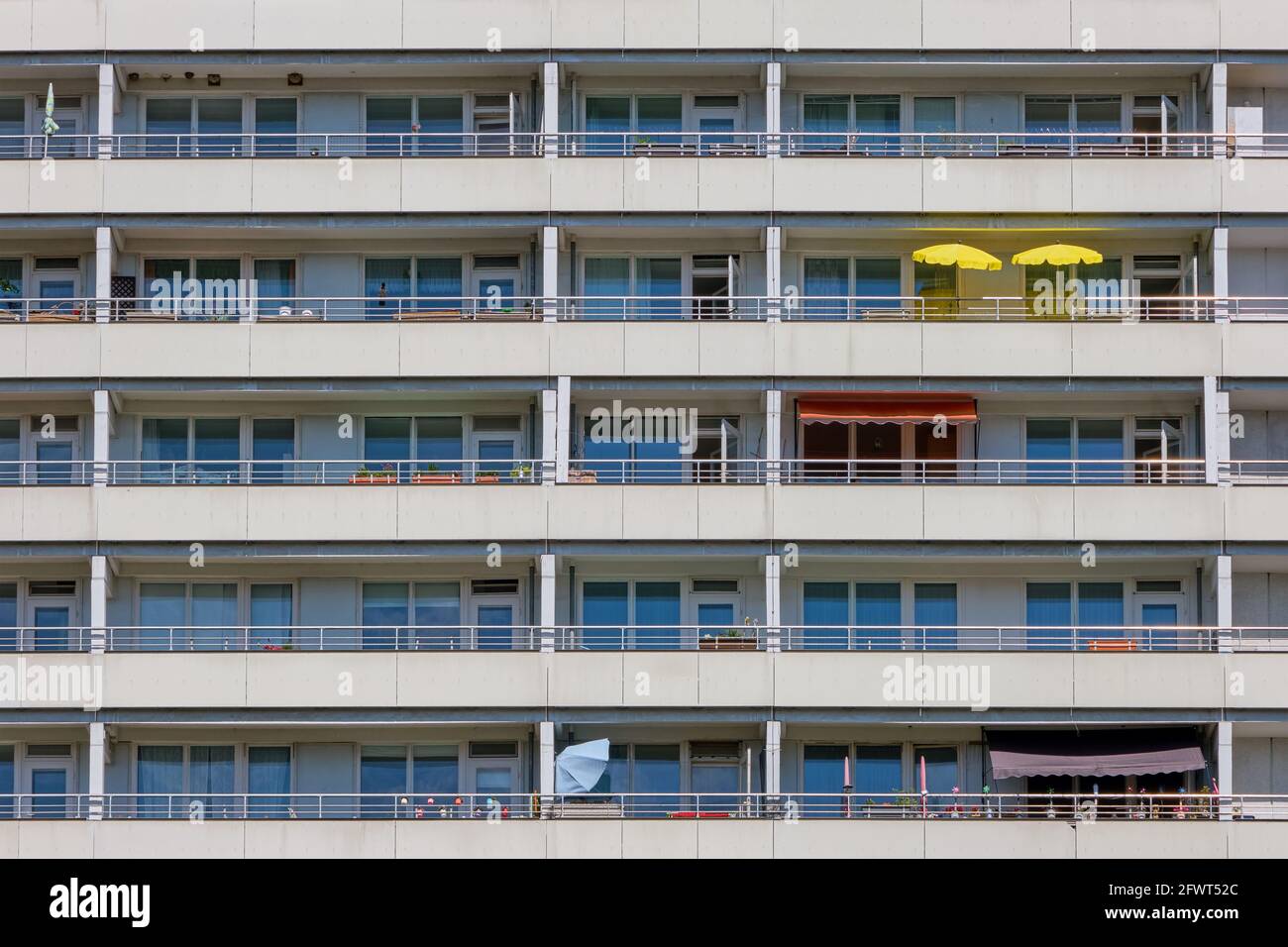 Façade d'un grand immeuble d'appartements avec des tons de soleil jaunes sur l'un des balcons Banque D'Images