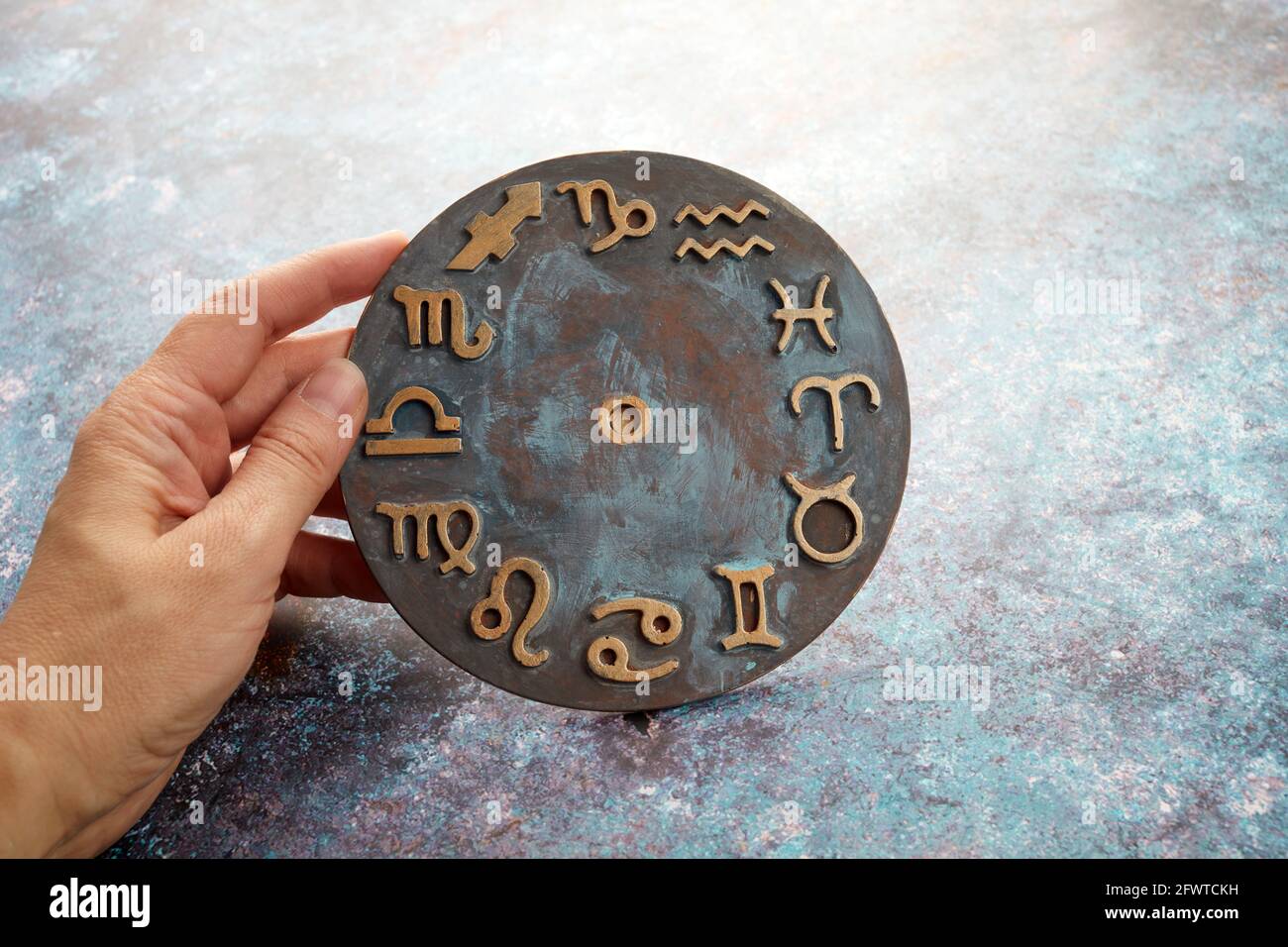 symbole d'horoscope de zodiaque avec mains de tueur de fortune sur fond rustique. Banque D'Images