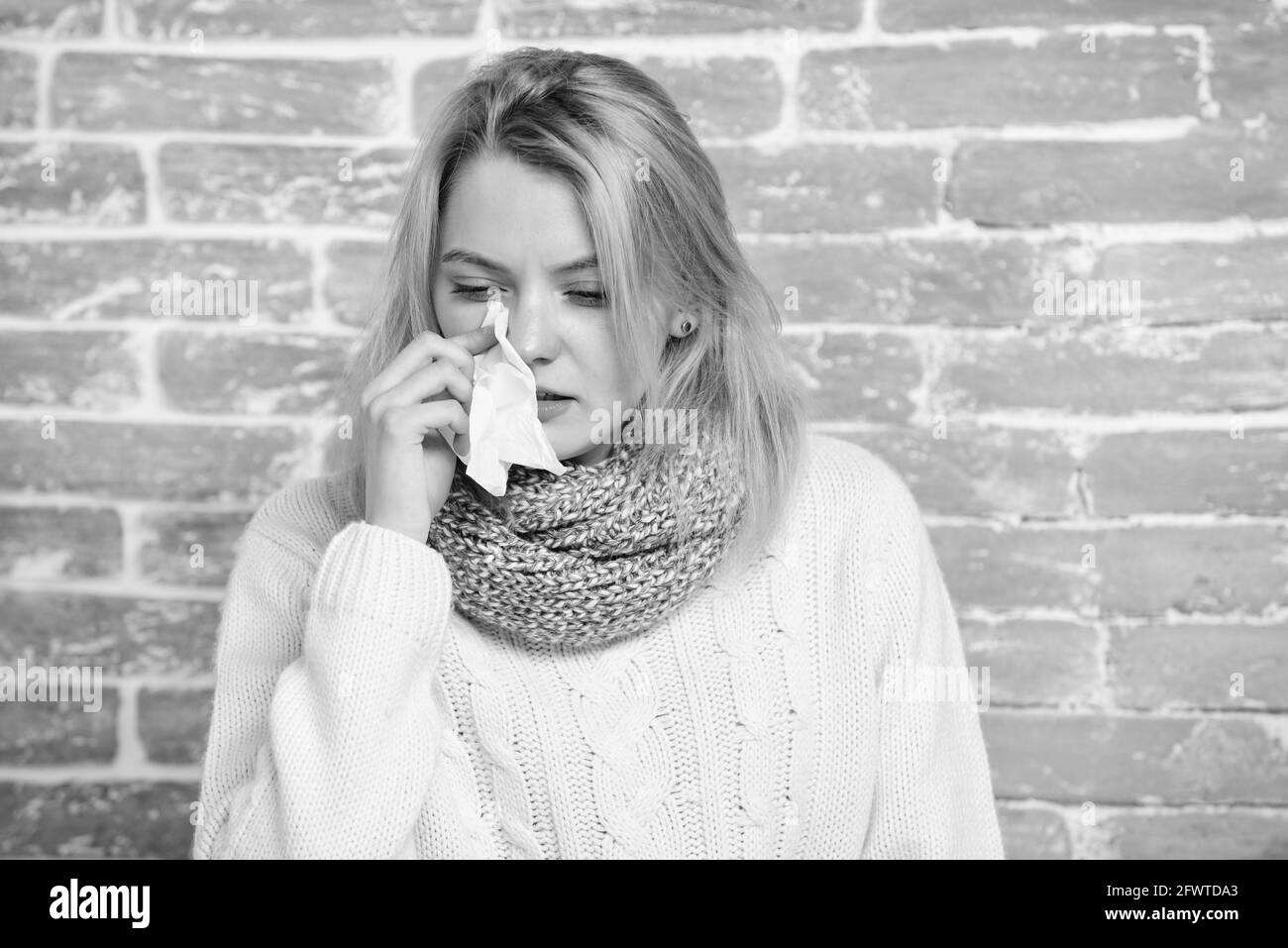 Une fille dans un foulard tient des tissus ou des serviettes souffrent de maux de tête. Symptôme liquide de nez du froid. Conseils comment se débarrasser du froid. Remèdes contre le froid et la grippe. Les solutions devraient aider Banque D'Images