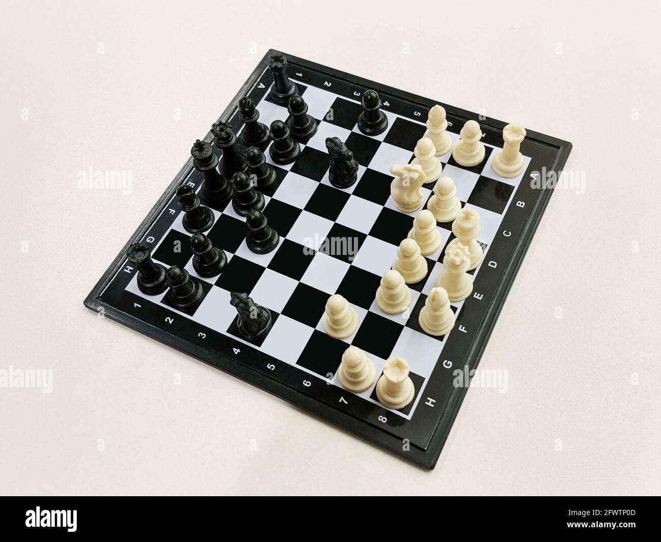 Vue en grand angle du jeu d'échecs de voyage sur un fond clair Banque D'Images