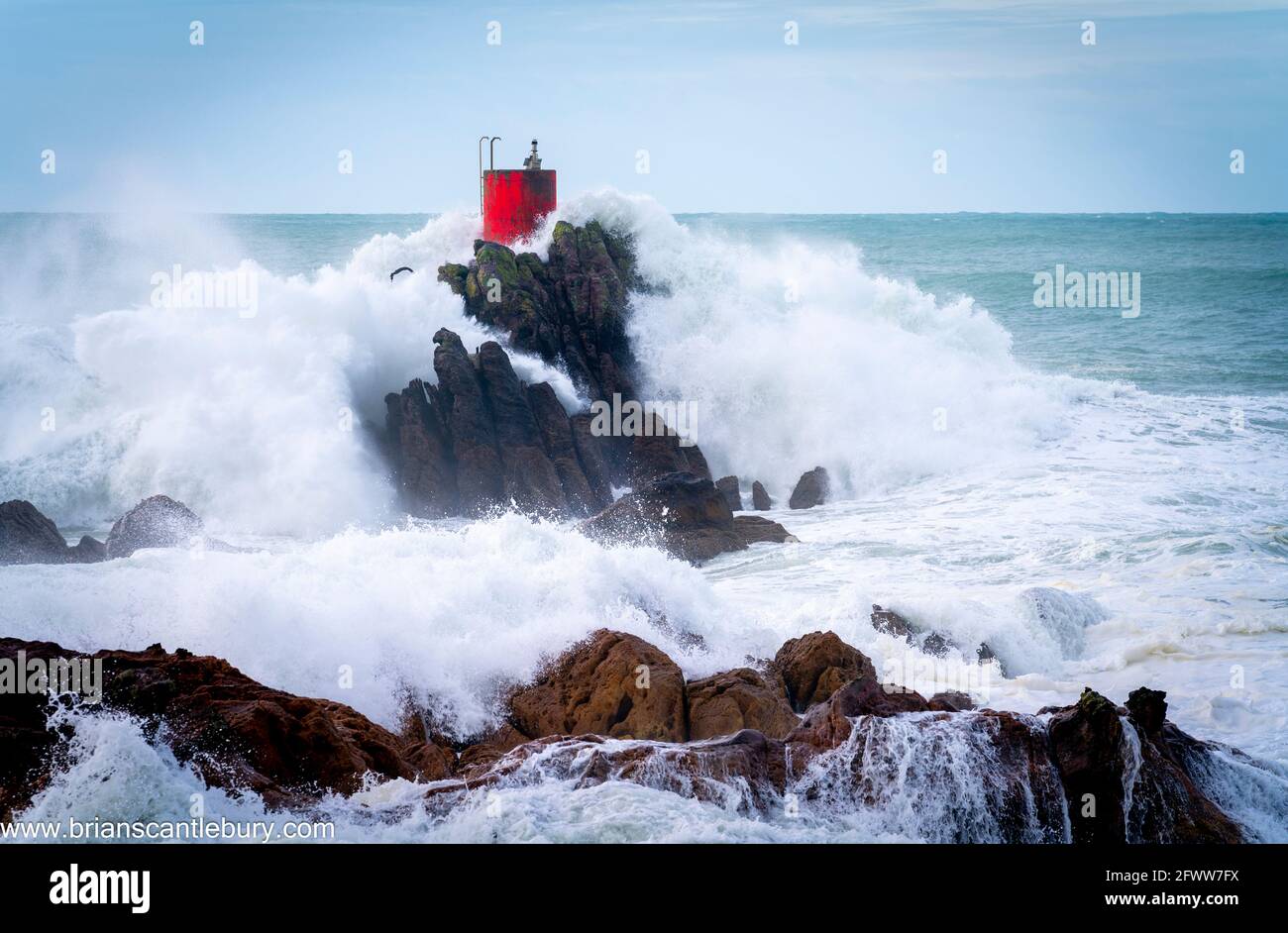 Structure rouge de balise sur North Rock enveloppée dans la mer Et vaporisez la base du mont Maunganui avec sauvage spectaculaire la mer de tempête s'est écrasant autour et au-dessus Banque D'Images