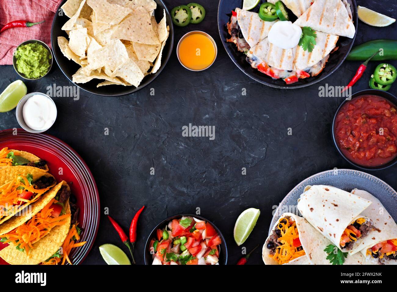 Cadre de cuisine mexicaine, au-dessus de la vue sur un fond d'ardoise sombre. Tacos, nachos, quesadilla et burritos. Copier l'espace. Banque D'Images