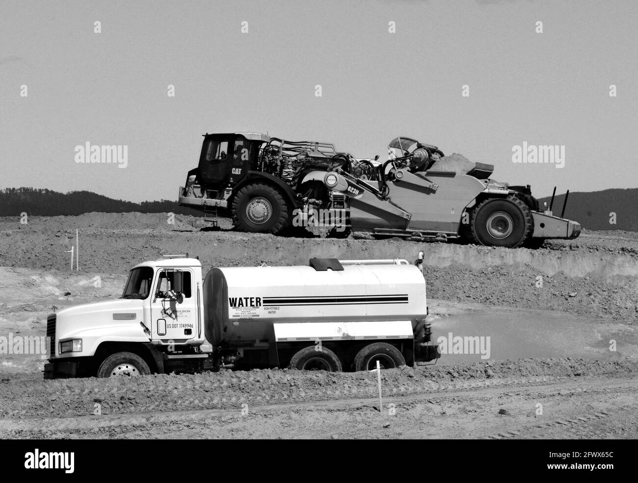 Les travailleurs de la construction de routes utilisent une décapeuse automotrice Caterpillar pour déplacer la saleté sur un chantier d'amélioration de la route à Santa Fe, au Nouveau-Mexique. Banque D'Images