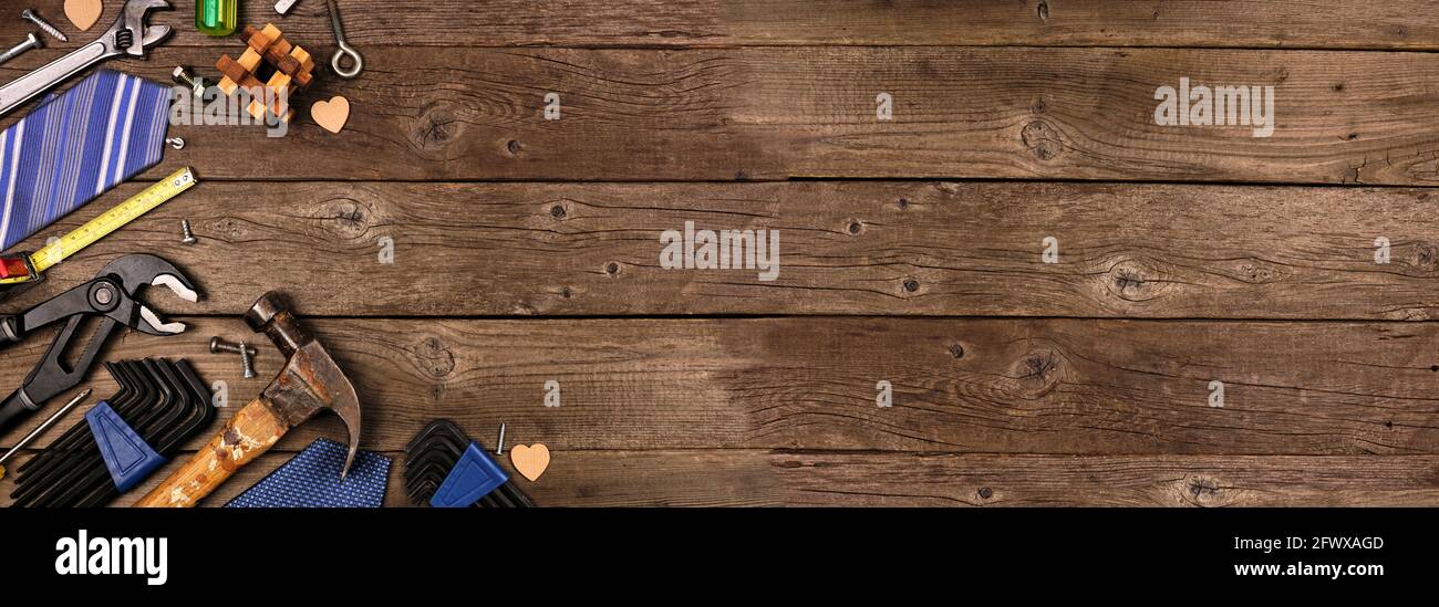 Fête des pères coin de thème bordure de cadeaux, cravate et outils sur un fond rustique de bannière en bois. Vue de dessus avec espace de copie. Banque D'Images