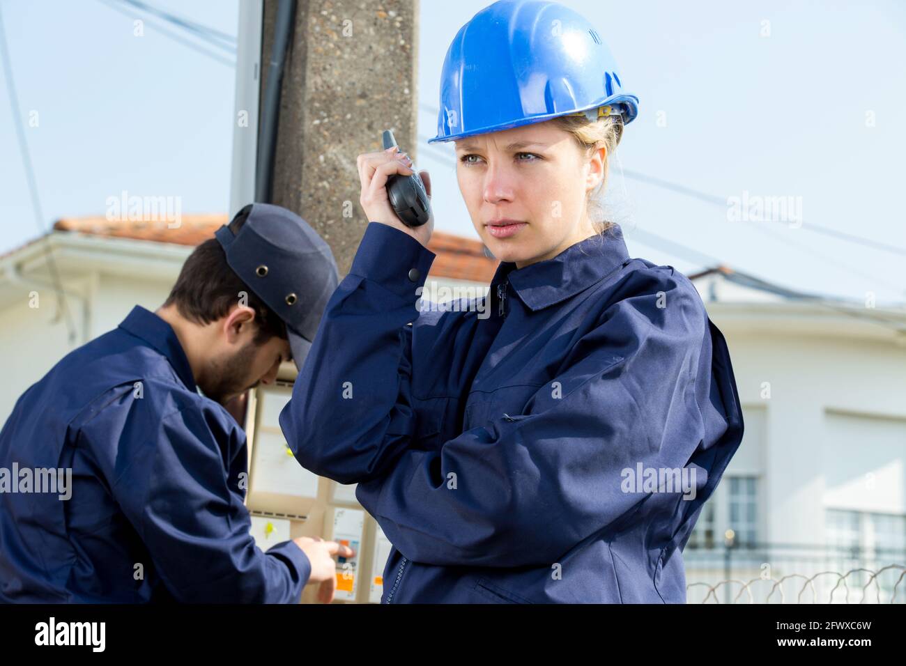 femme technicien lisant l'électricité à l'extérieur Banque D'Images