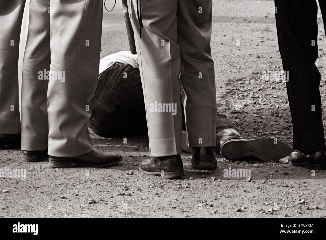 Manifestant contre la guerre du Vietnam sur le terrain, parmi les jambes en uniforme Banque D'Images