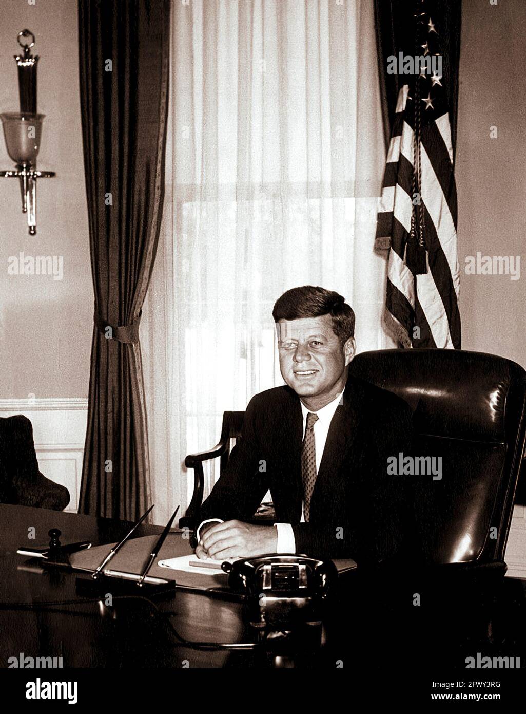 Photo portrait du Président John F. Kennedy à son bureau dans le Bureau ovale de la Maison Blanche, Washington, D.C. il s'agit de la première photo de la Maison Blanche faite du Président à son bureau. Banque D'Images