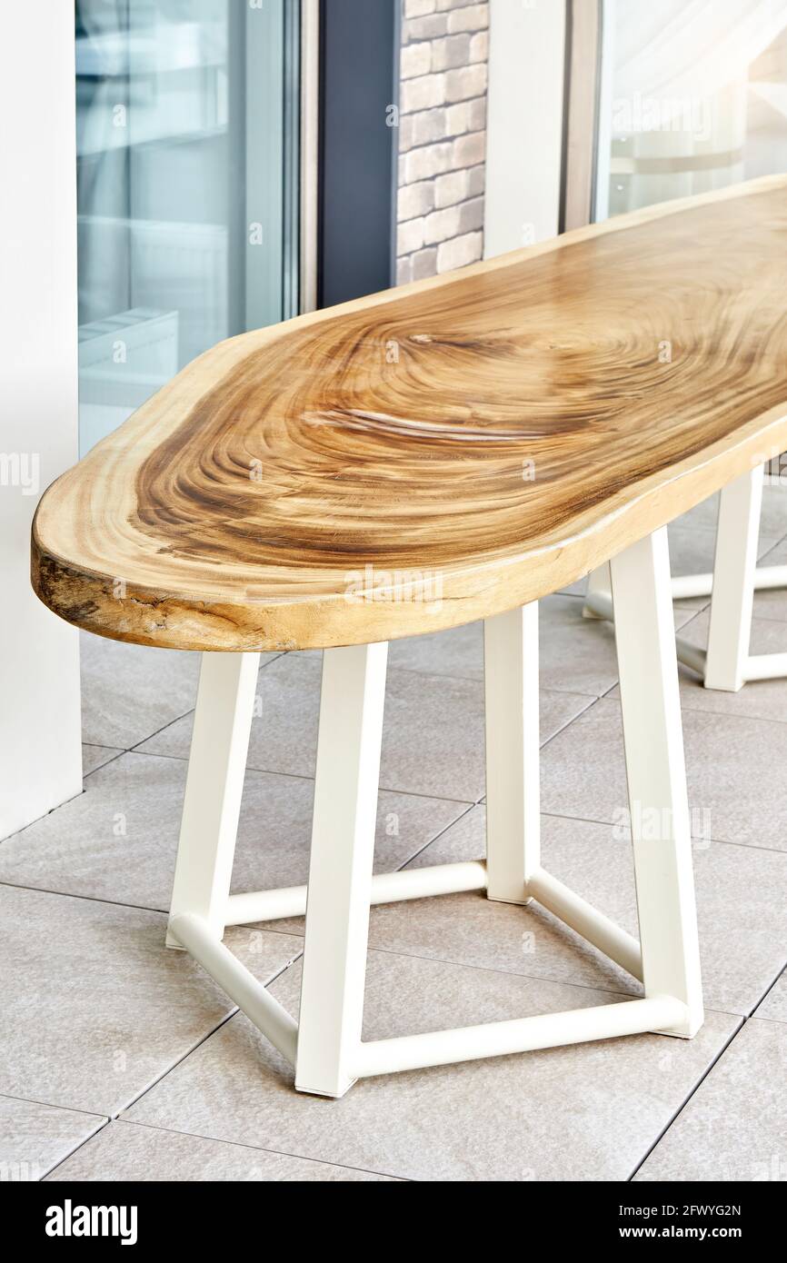 Magnifique table à manger design en grand laqué dalle de bois de suar sur des supports de carcasse en métal dans la cour de chalet élégant à deux pas Banque D'Images