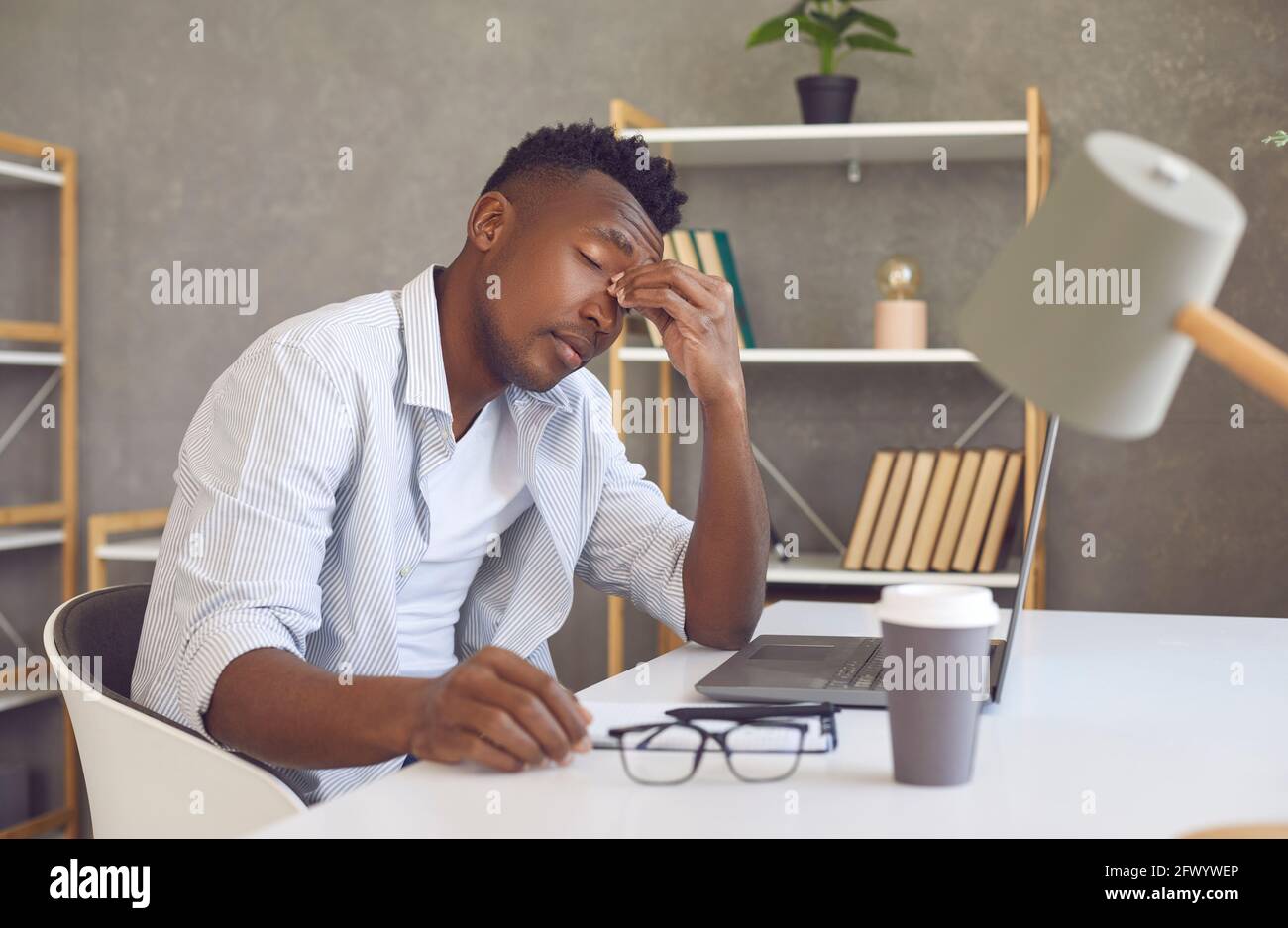 Un homme fatigué souffrant de la tension de l'œil de l'ordinateur frotte le pont de nez bureau de travail Banque D'Images