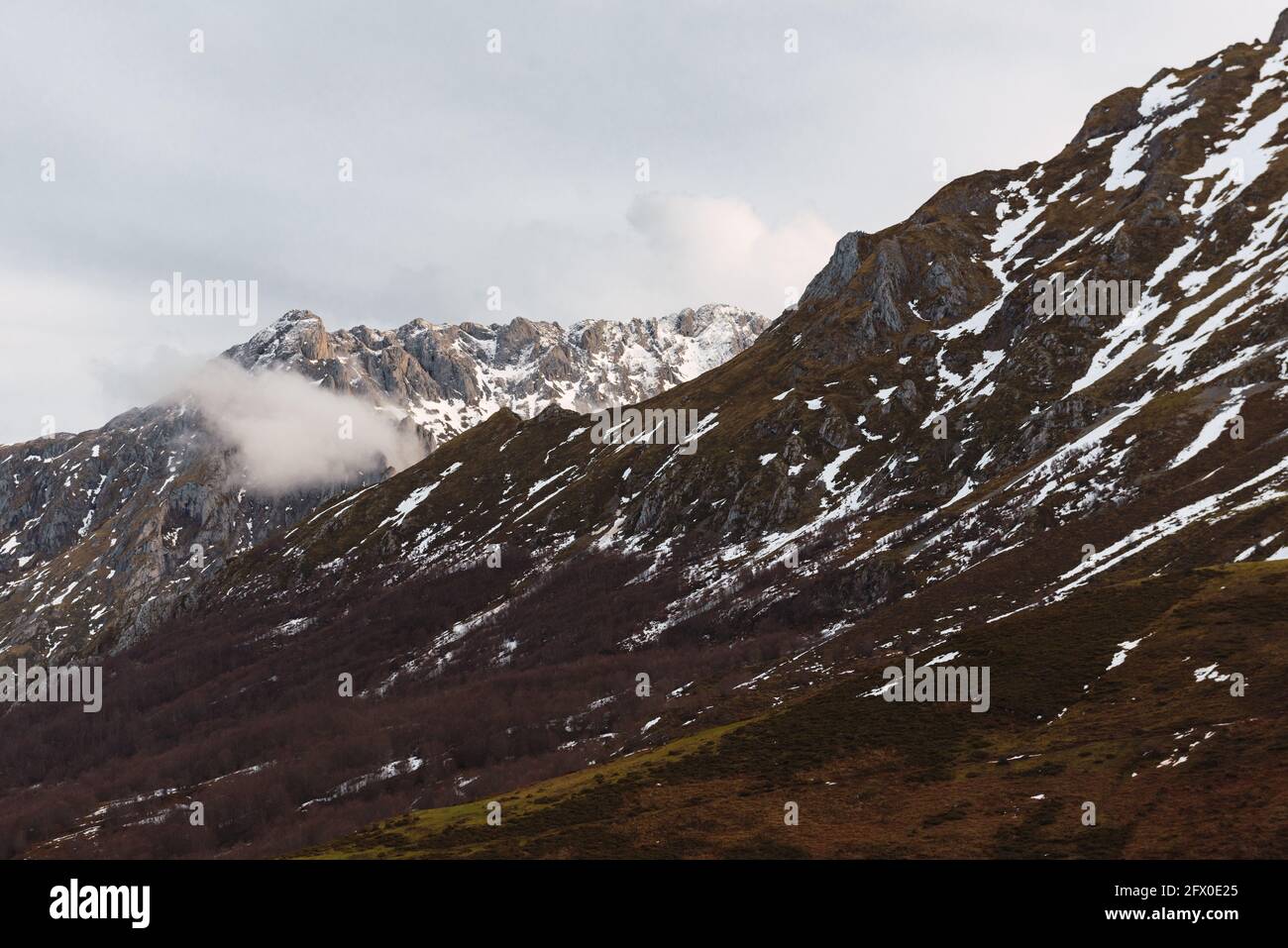 Paysage grand angle des sommets de l'Europe avec la neige et brouillard sous les nuages pendant la soirée Banque D'Images