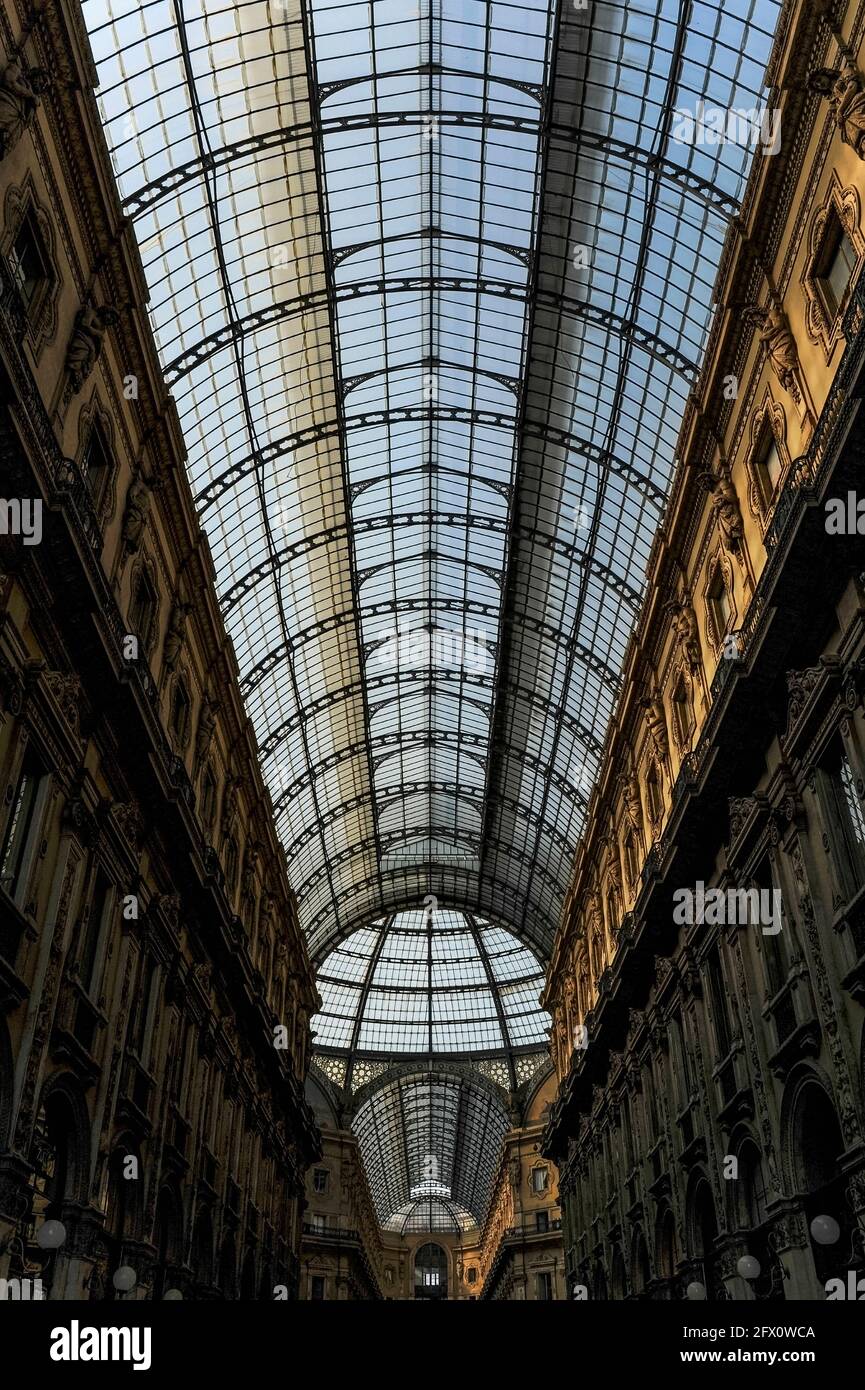 Vue en perspective de l'une des deux arcades, voûtée en verre et en fonte, qui se croisent sous un dôme vitré pour former l'un des plus élégants centres commerciaux du monde, la Galleria Vittorio Emanuele II à Milan, Lombardie, Italie. La Galleria, construite de 1865 à 1877 pour relier la Piazza del Duomo et la Piazza della Scala, qui abrite l'opéra Teatro alla Scala, porte le nom du premier monarque du Royaume d'Italie. Il abrite quelques-unes des marques de mode haut de gamme les plus connues au monde, ainsi que des marchands de livres et d'art et certains des plus anciens et meilleurs restaurants de la ville. Banque D'Images