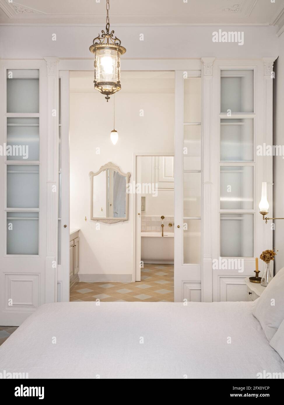 Intérieur de chambre de style rétro ou classique avec lustre vintage. Vue  sur la salle de bains décorée dans des tons de beige avec zone de baignoire  Photo Stock - Alamy