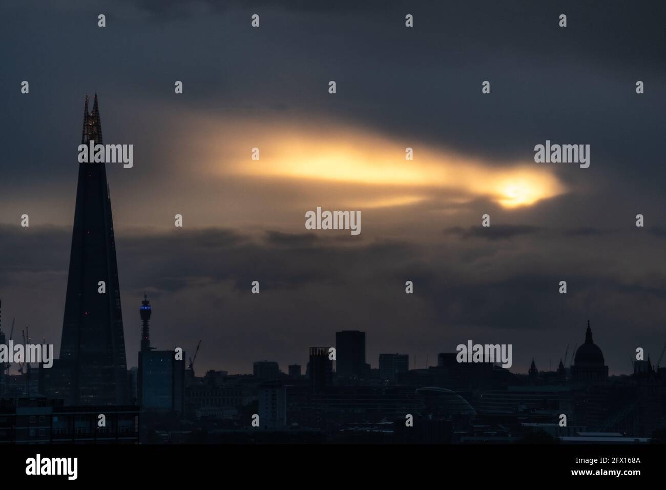 Londres, Royaume-Uni. 24 mai 2021. Météo au Royaume-Uni : une pause dans les nuages permet à la lumière du soleil de la dernière soirée d'éclater au-dessus de la ville avec le gratte-ciel de Shard et les monuments de la cathédrale Saint-Paul en vue. Credit: Guy Corbishley/Alamy Live News Banque D'Images