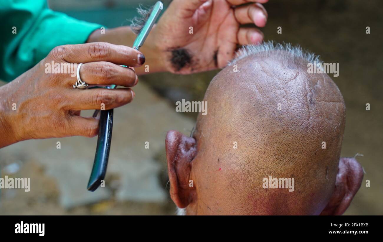 Personnes non identifiées dans un salon de coiffure professionnel dans un salon de rue. Service de rasage porte à porte en Inde. Banque D'Images