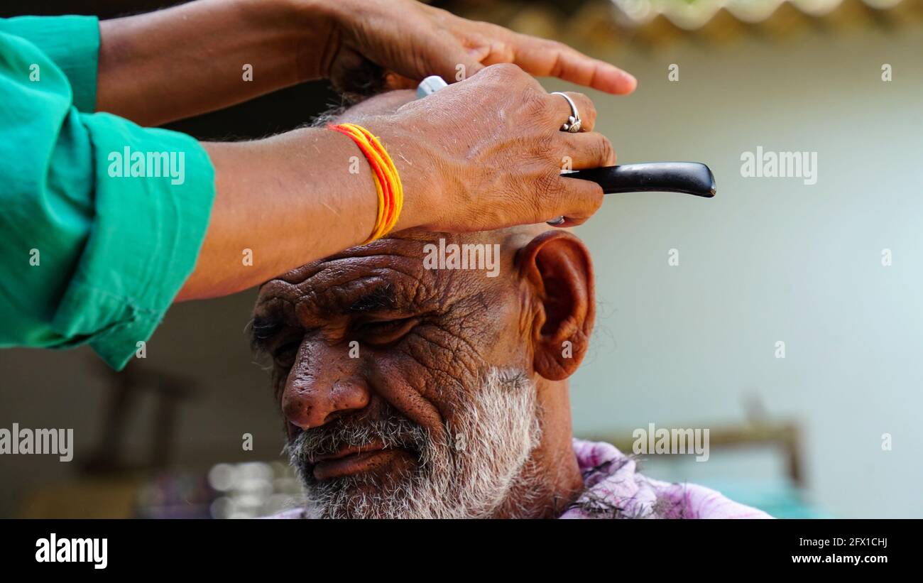 01 janvier 2021- Reengus, Sikar, Inde. Un coiffeur traditionnel est de raser UN homme dans le village de Sikar, en Inde. Banque D'Images