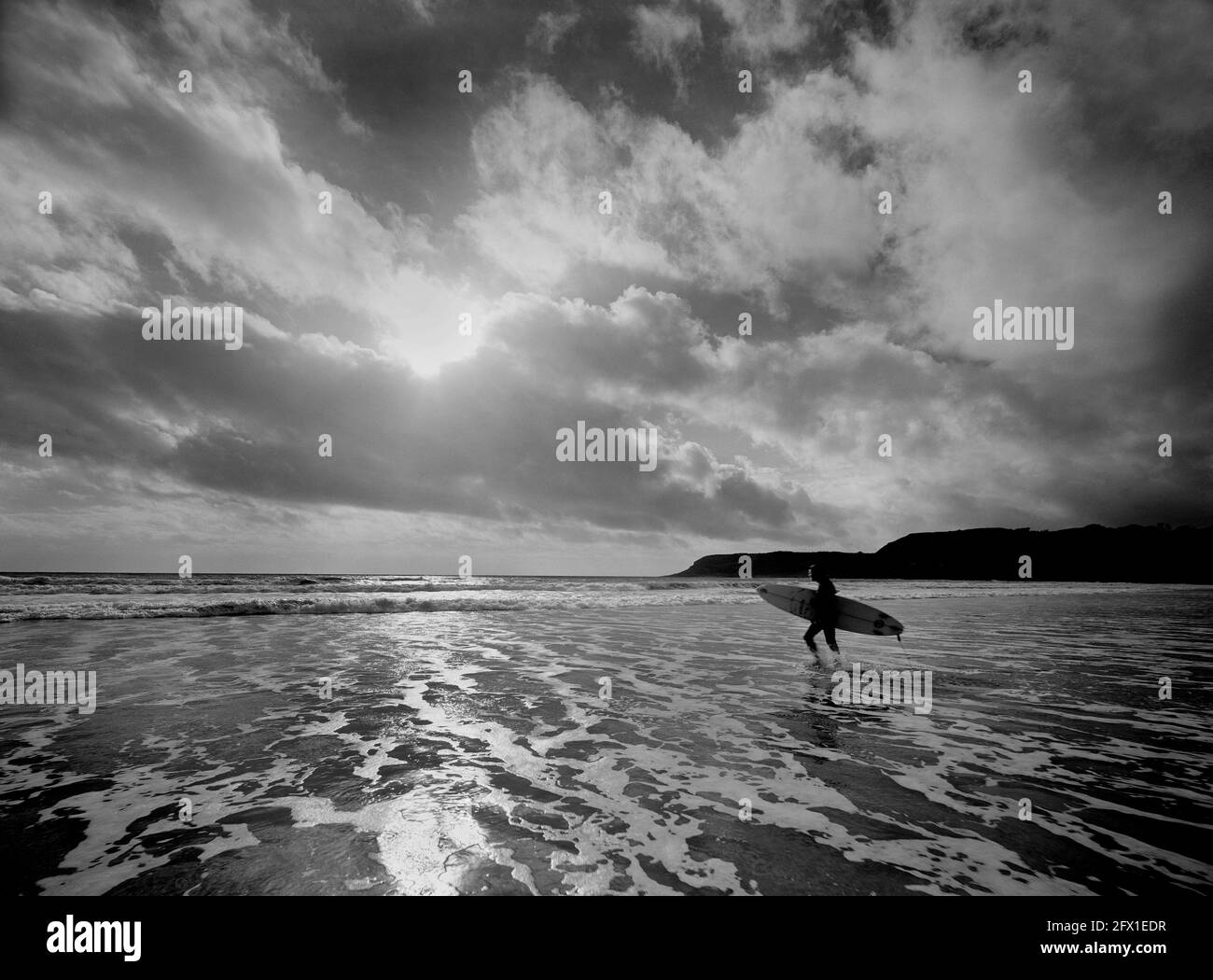Noir et blanc de surfer transportant une planche à l'intérieur l'espace sea .clouds & sky copy Banque D'Images