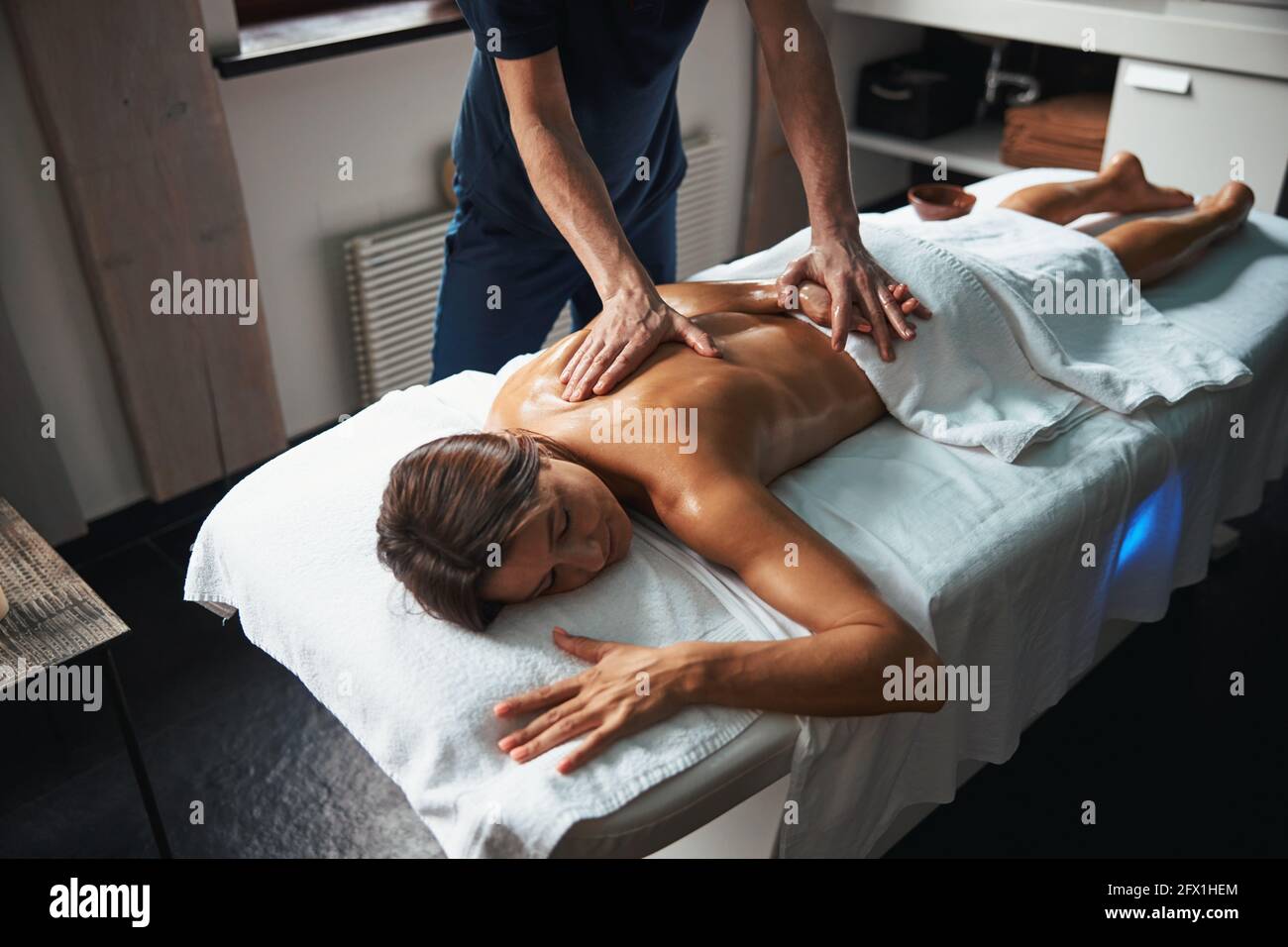 Belle jeune femme sous la serviette de détente à l'arrière massage au spa  Photo Stock - Alamy