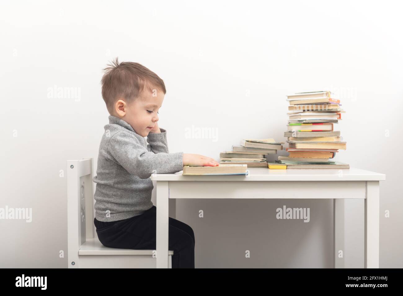 Gros plan de livres de lecture de petit garçon mignon dans sa chambre. Concept d'enfance heureuse Banque D'Images