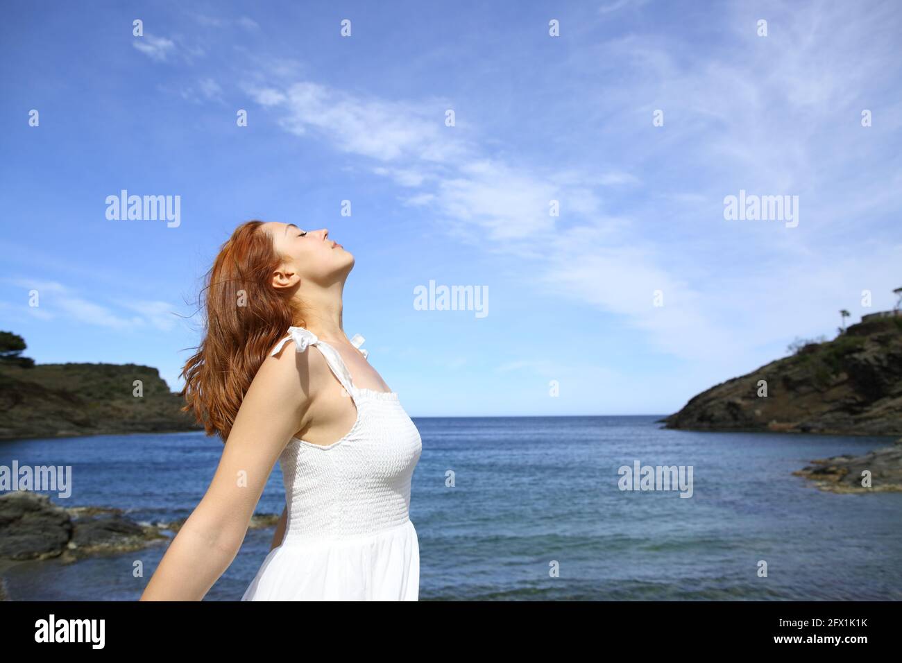 Profil d'une dame décontractée en robe blanche respire frais air sur la plage Banque D'Images