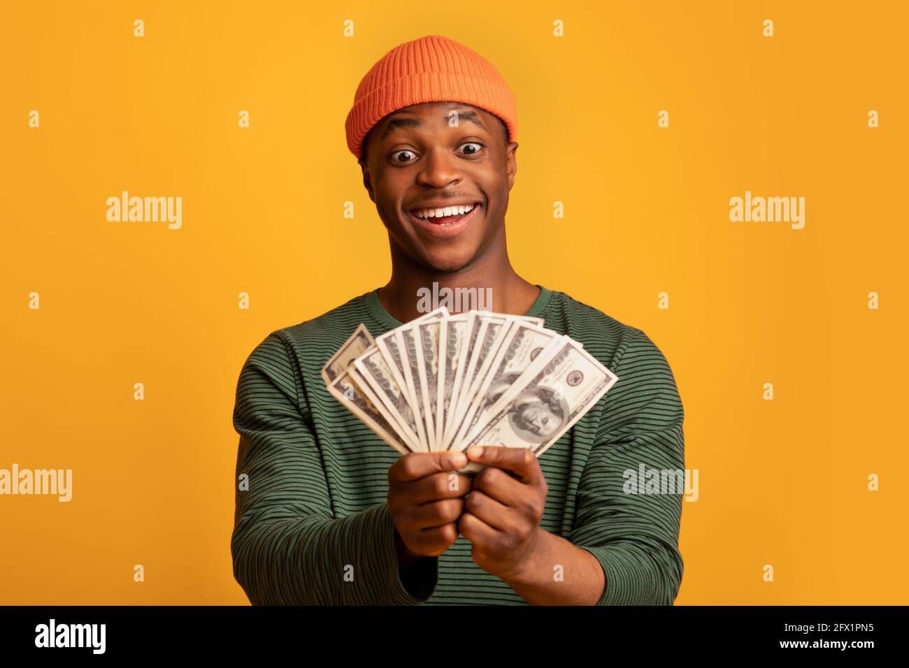 Grand prix. Surjoyeuse jeune homme de taille basse noir tenant Dollar Cash Fan Banque D'Images