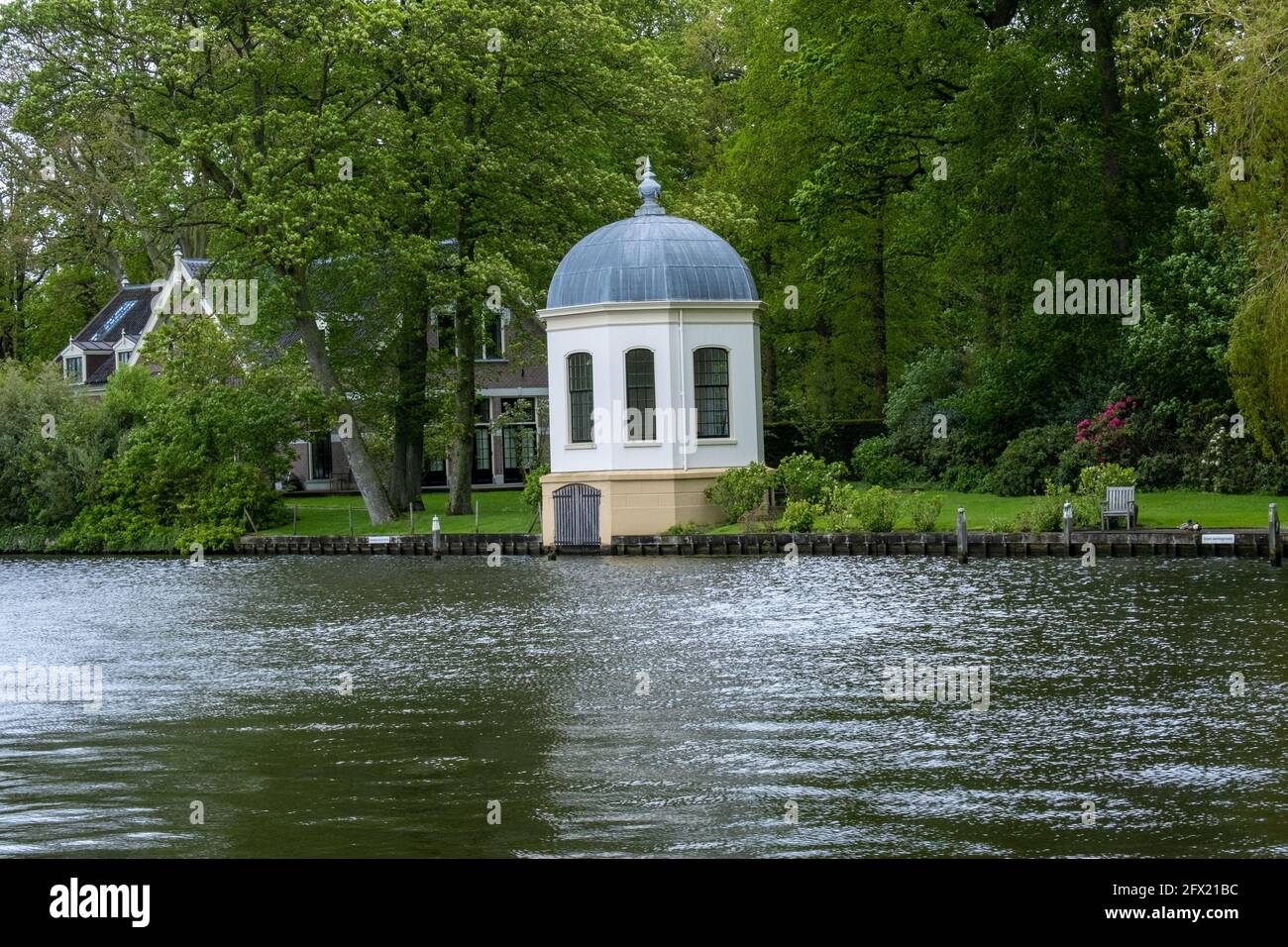 un grand plan d'eau entouré d'arbres et d'un bâtiment en arrière-plan Banque D'Images